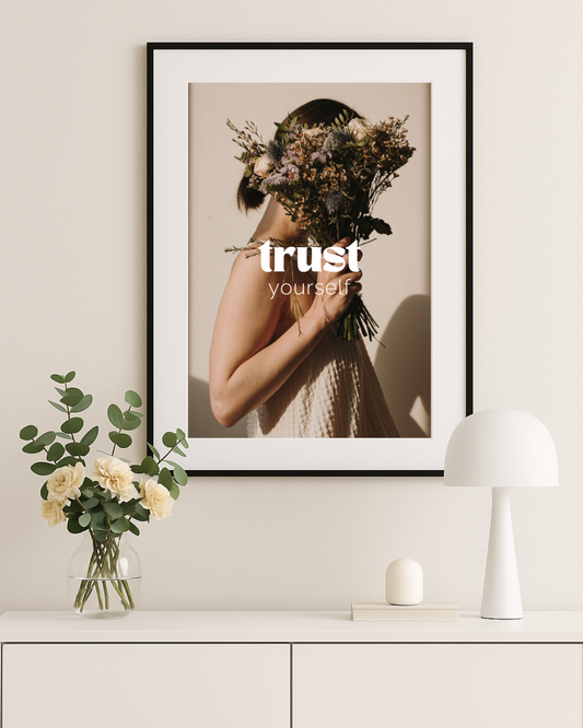 Vistam Affirmationsposter "trust yourself" in schwarzem Rahmen über weißem Regal.