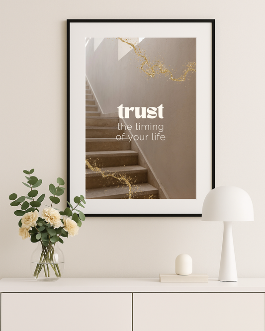 Vistam Affirmationsposter "trust the timing of your life" in schwarzem Rahmen über weißem Regal.