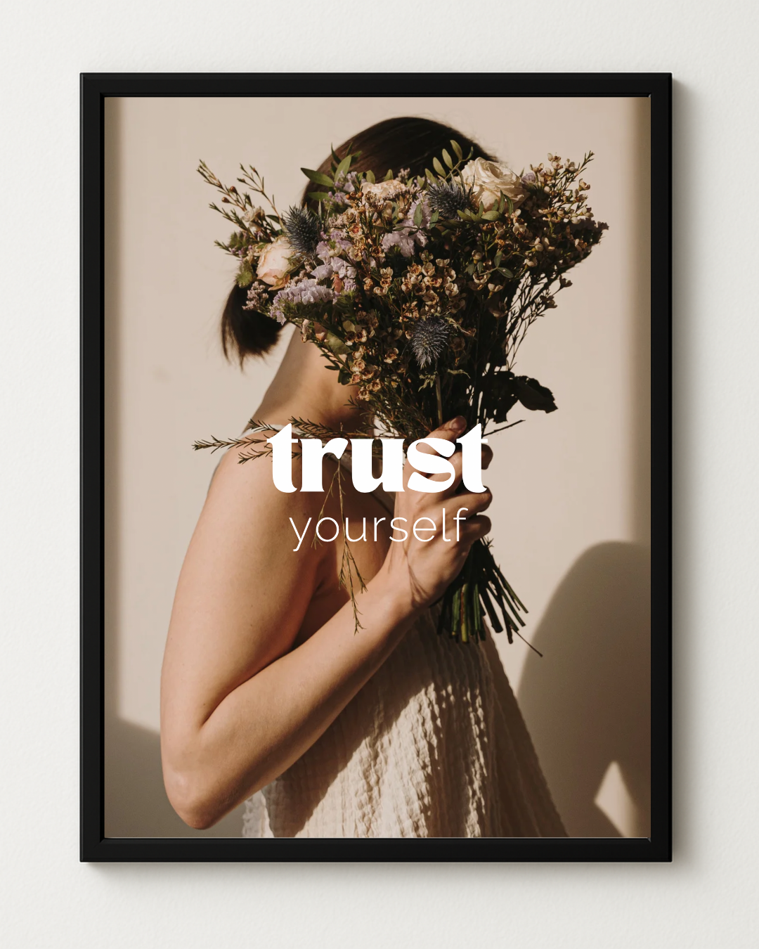Affirmationsposter "trust yourself" in schwarzem Rahmen vor weißem Hintergrund.